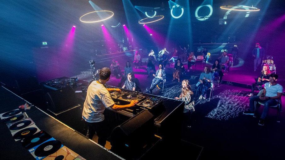 Taking no dances: DJ entertains clubbers sitting on chairs a strict 1.5metres apart PICTURES: REUTERS